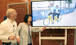 Jose and Wendy Perey cheer as they see a photo of themselves on a TV screen